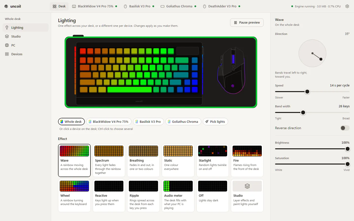 The uncoil desktop app’s Lighting screen: the desk drawn to scale and lit with the wave, cards for every effect from Wave to Off plus Studio, and the wave’s direction, speed, band width, reverse, brightness and saturation controls.